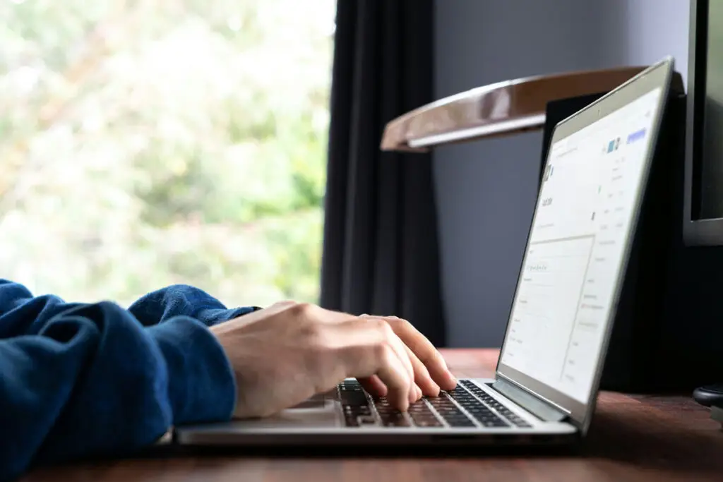 hands typing on laptop