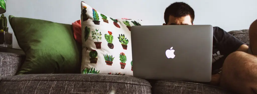 a man sitting on a couch with a laptop