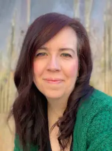 a woman with long brown hair wearing a green sweater