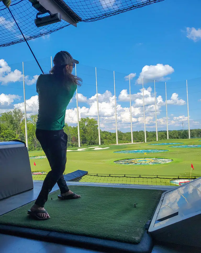 a woman swinging a golf club