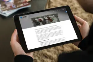 hands holding a tablet with a website on it