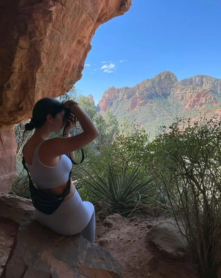 a woman taking a picture of a canyon