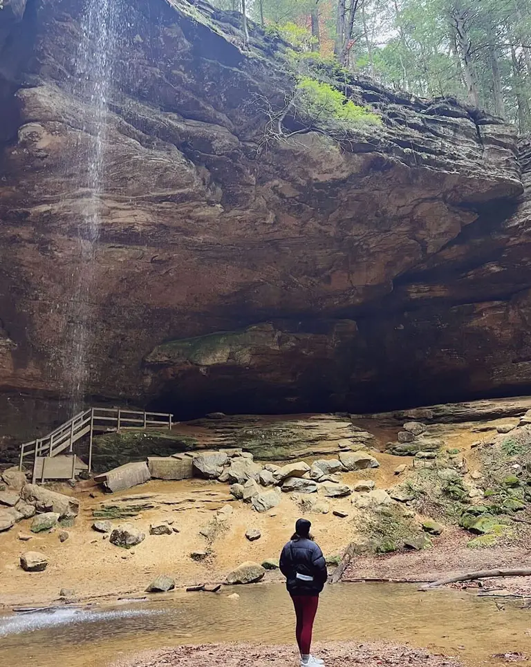 a man standing in front of a waterfall