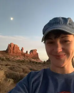 a woman taking a selfie in front of a rock formation