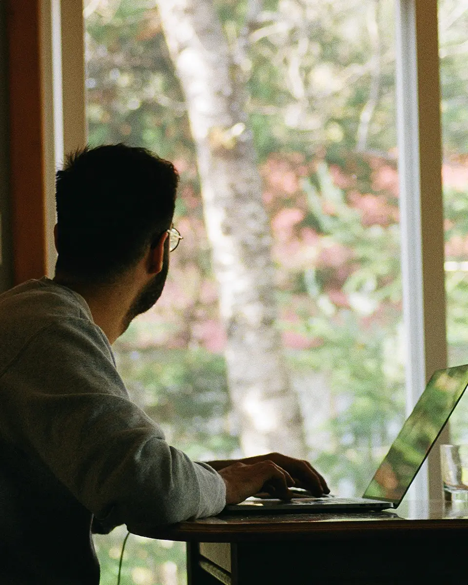 a man sitting at a desk with a laptop