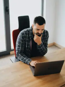 a man sitting at a desk with a laptop