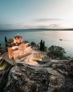 a building on a hill overlooking a body of water